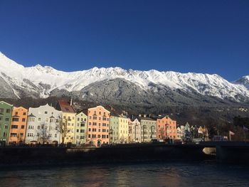 Scenic view of river and mountains against clear blue sky