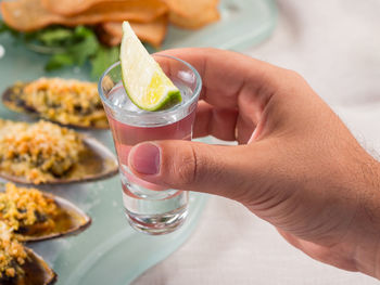 Cropped hand holding glass of drink