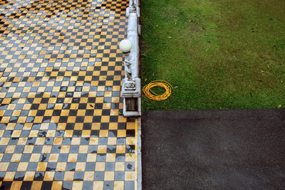 High angle view of wet footpath by grass