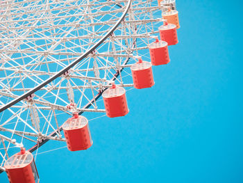 Low angle view of ferris wheel against clear blue sky