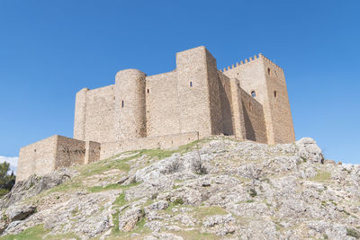 Low angle view of old ruins against clear blue sky