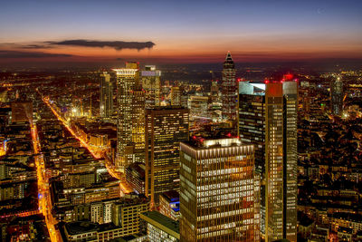 Aerial view of illuminated city buildings during sunset