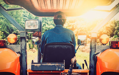 Rear view of man sitting on tractor