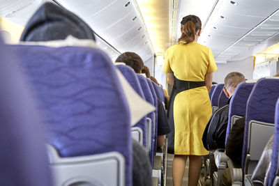 Rear view of airhostess in airplane