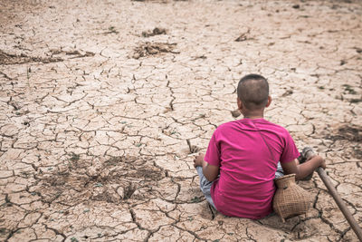 Boy sitting on sand