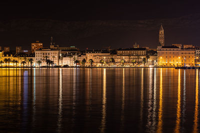 Illuminated buildings in water at night
