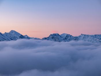 Scenic view of snowcapped mountains against sky during sunset