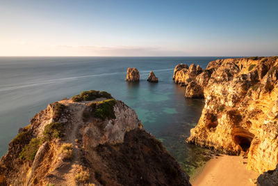 Scenic view of rocks in sea against sky