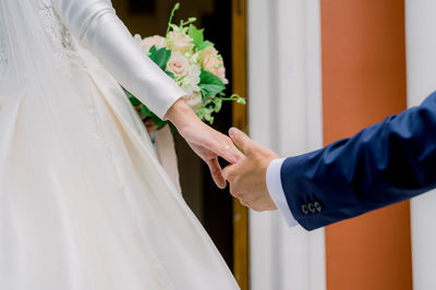 Crop newlyweds holding hands during wedding