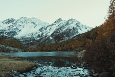 Scenic view of lake and snowcapped mountains against sky, late hour, last shot