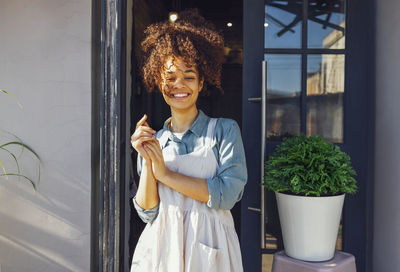 Portrait of young woman standing by window