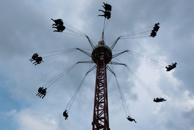 Low angle view of chain swing ride against sky