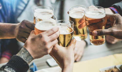 Cropped image of friends raising toast at restaurant