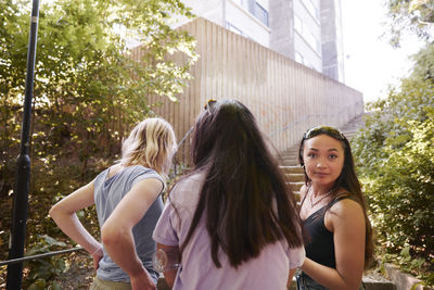 Three young female friends standing together and talking