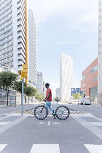 Man with a bicycle crossing a crosswalk.