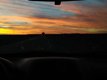 Car on road against sky during sunset