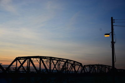 Low angle view of silhouette bridge against sky during sunset