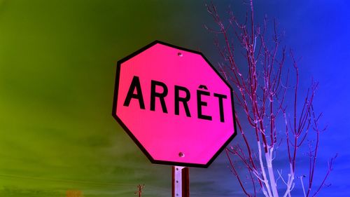 Close-up of road sign against blue sky