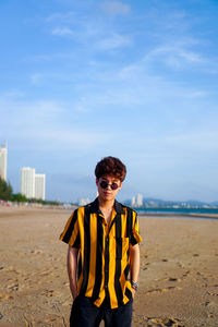 Portrait of mid adult man standing on beach
