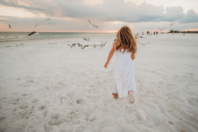 Rear view of woman standing on beach