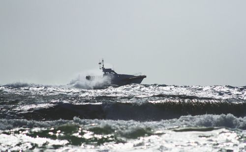 Ship sailing in sea against clear sky