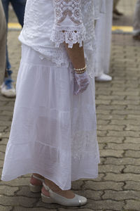 Low section of woman standing on footpath