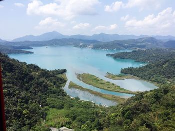 High angle view of lake and mountains against sky