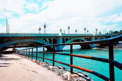 Bridge over river in city against sky