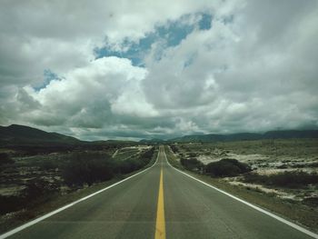 Empty road leading towards mountains