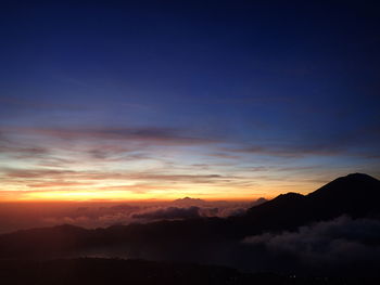 Scenic view of silhouette mountains against sky during sunset