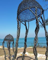 Fishing net on beach against clear blue sky