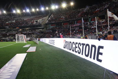 Group of people relaxing on soccer field at night