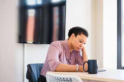 Serious young businesswoman using graphics tablet in office