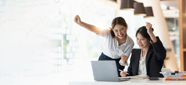 Side view of woman using digital tablet while standing in office