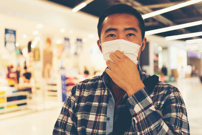 Portrait of man wearing mask standing at store