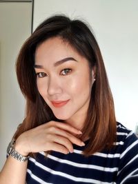 Close-up portrait of woman smiling while standing at home