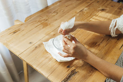Cropped hand of woman holding food on table