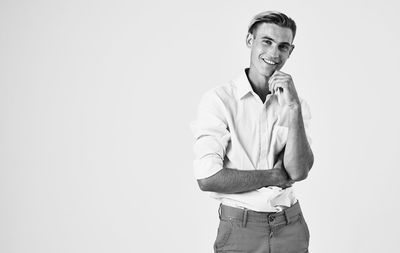 Portrait of young man standing against white background