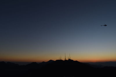 Scenic view of silhouette mountains against clear sky during sunset