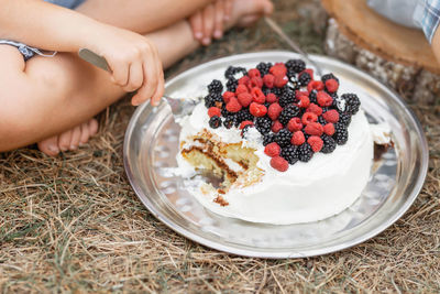 Low section of boy eating cake