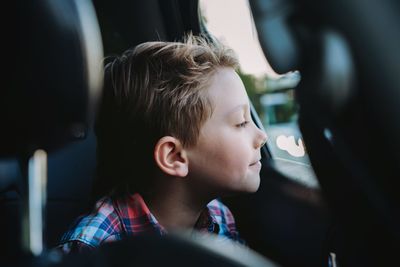 Handsome caucasian boy travelling by car sitting in child seatrecreation concept