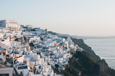 High angle view of townscape by sea against clear sky