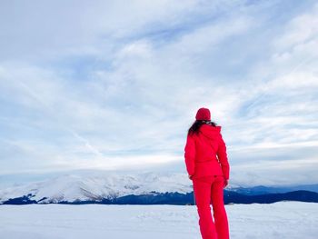 Rear view of woman standing on snow covered landscape