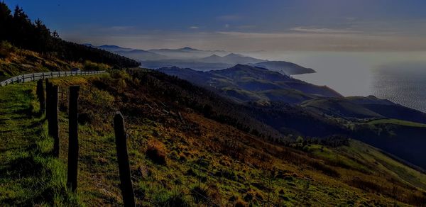Scenic view of sea and mountains against sky