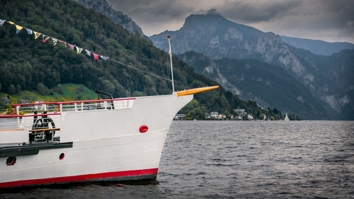 Boat in traunsee lake, cloudy mountains on background