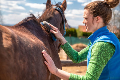 Side view of two people riding horse