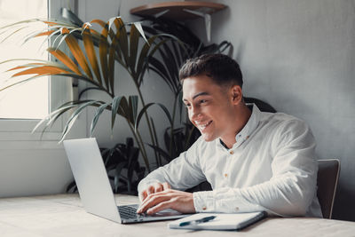 Young businesswoman using laptop at table