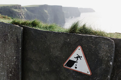 Close-up of warning sign on cliff