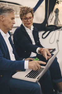 Senior couple discussing over laptop while traveling in yacht