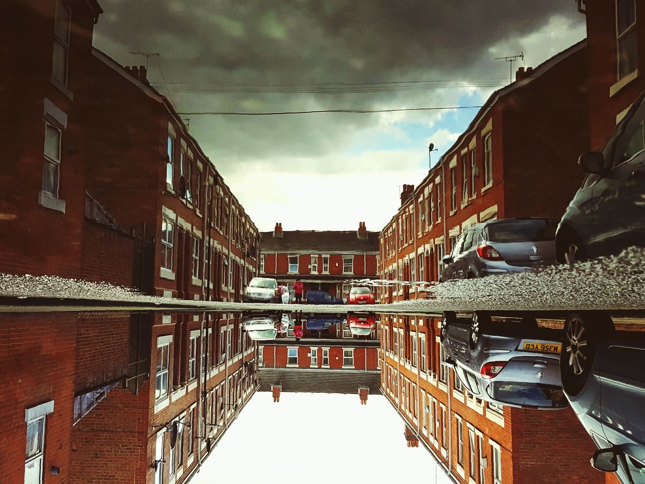 architecture, built structure, building exterior, sky, low angle view, city, building, cloud - sky, residential building, residential structure, transportation, connection, diminishing perspective, cloud, cable, cloudy, outdoors, street, window, no people